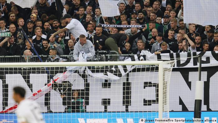 Gladbach-Fans entfernen auf der Tribüne ein Banner mit einer Beleidigung gegen Ex-Sportchef Max Eberl und RB Leipzig