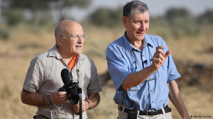 Volker Schlöndorff steht links mit einer Kamera in der Hand, neben ihm steht ein gestikulierender Tony Rinaudo im blauen Hemd.