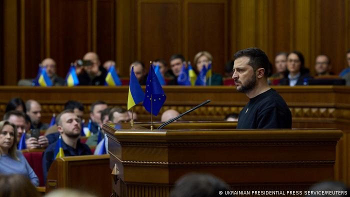 Wolodymyr Selenskyj am Rednerpult, Abgeordnete mit ukrainischen Fähnchen