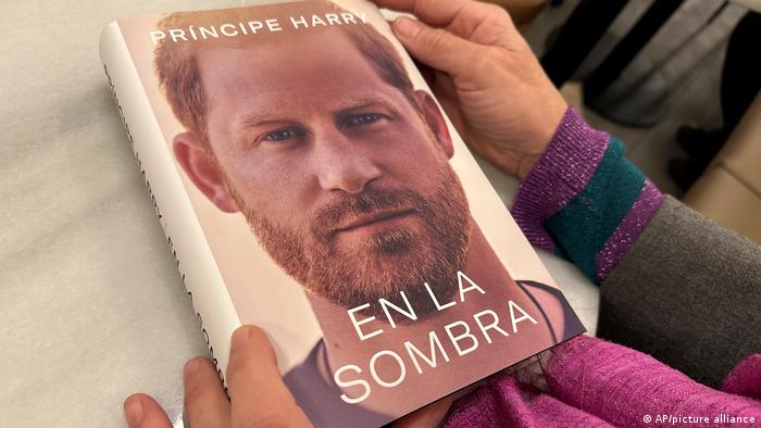 Eine Frau hält eine Kopie von En La Sombra, der spanischen Übersetzung von Prinz Harrys Memoiren Spare.