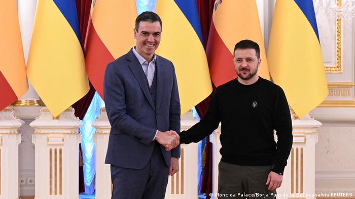 Der spanische Ministerpräsident, Pedro Sanchez (l.), und der Präsident der Ukraine, Wolodymyr Selenskyj, geben sich die Hand und schauen dabei in Richtung Kamera